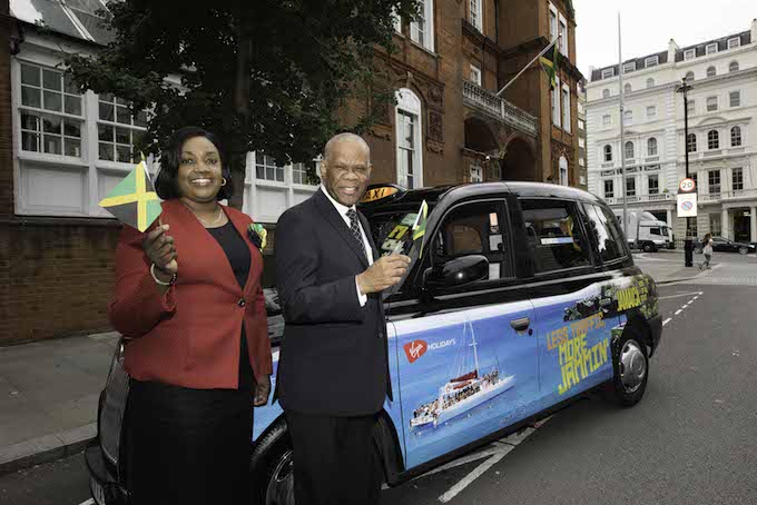 Deputy High Commissioner Angela Rose Howell and His Excellency Seth George Ramocan, Jamaican High Commissioner to the UK, with one of the Jamaica wrapped taxis outside the Jamaican High Commission in London