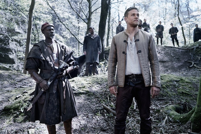 Djimon Hounsou as Bedivere and Charlie Hunnam as Arthur in a scene filmed in Seven Sisters Wood, Forest of Dean. © 2017 Warner Bros. Entertainment, Inc. All rights reserved